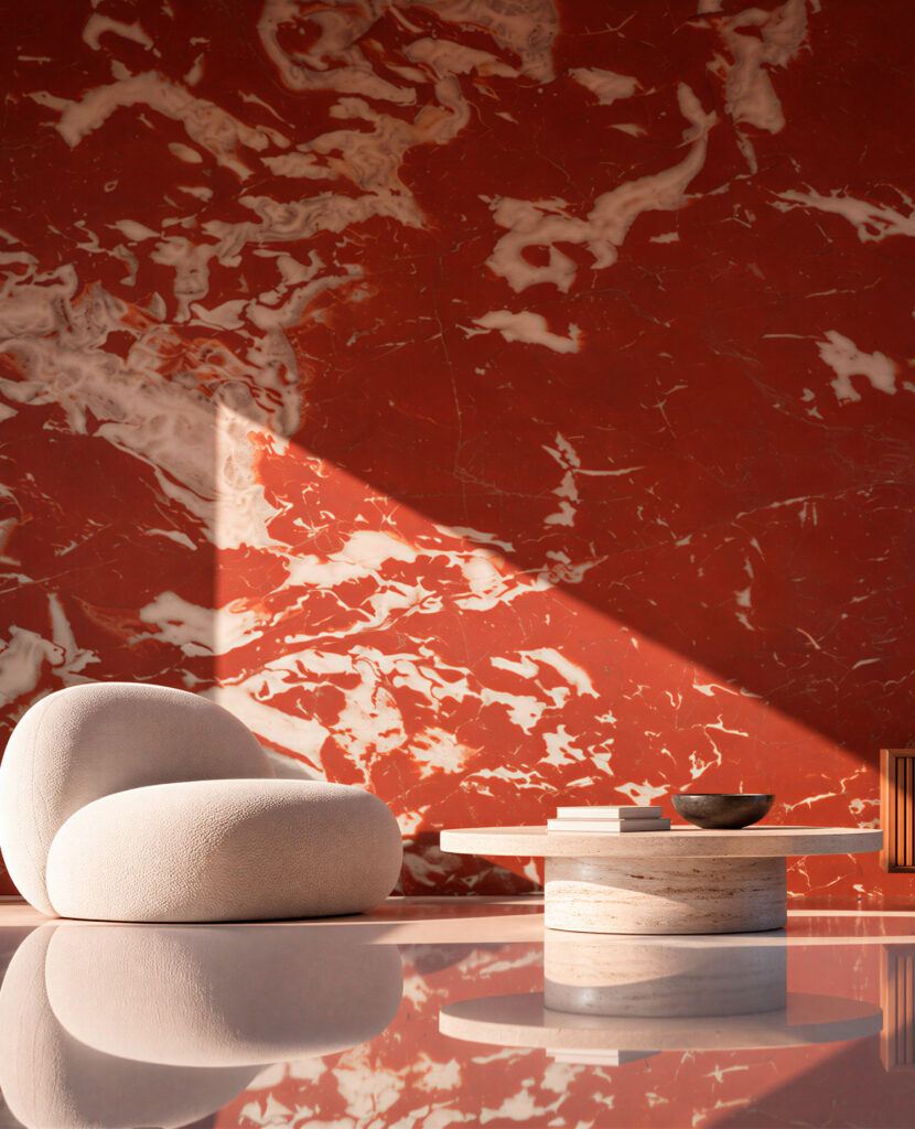 Sillón blanco y mesa baja ante una pared de mármol rojo veteado